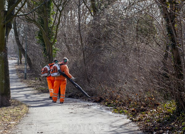 Employees of the horticultural office at work with the leaf blower