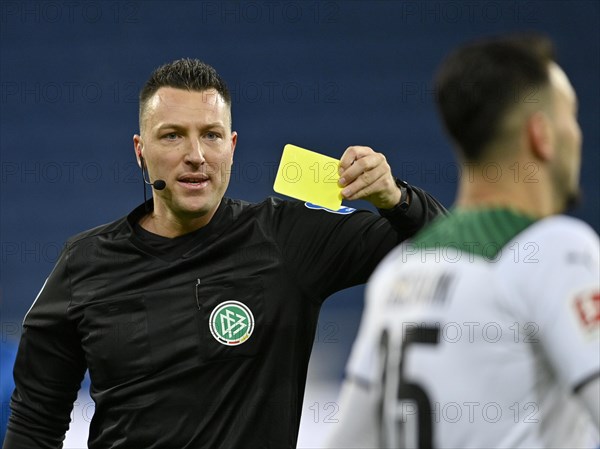Referee Sven Jablonski shows yellow card to Ramy Bensebaini Borussia Moenchengladbach BMG