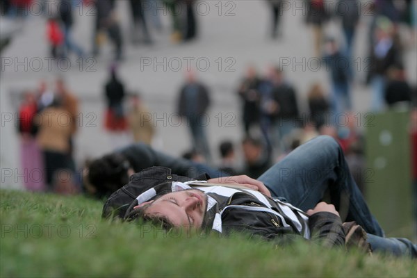 Young man sleeps off beer binge in a meadow