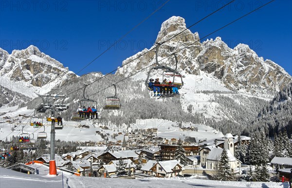 Skiers on a chairlift in the winter resort of La Villa