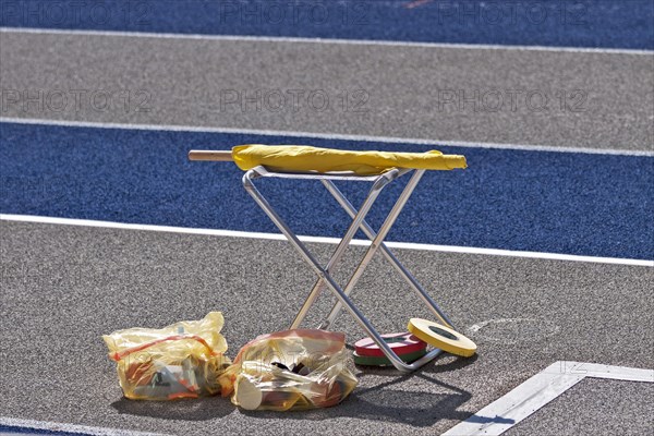 Stools and rubbish bags stand next to the tartan track at an athletics event in the Olympic Stadium