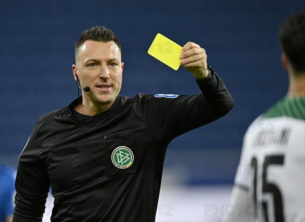 Referee Sven Jablonski shows yellow card to Ramy Bensebaini Borussia Moenchengladbach BMG