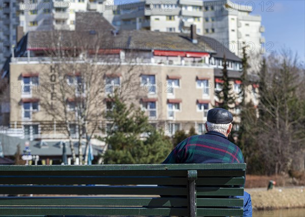 Senior sitting on a park bench at the Segeluchbecken in the Maerkisches Viertel