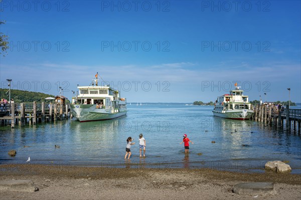 Children playing and ships at the jetty of Herreninsel