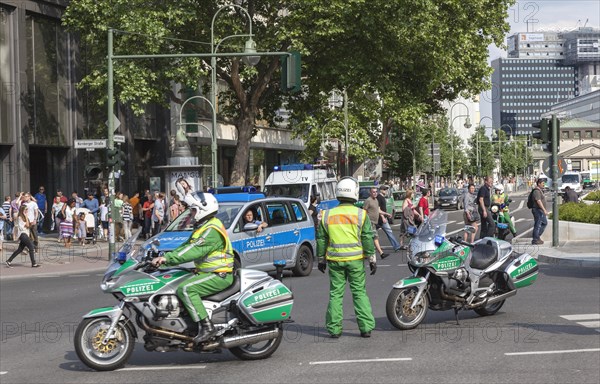 Traffic police officers on a motorbike regulate traffic during a demonstration