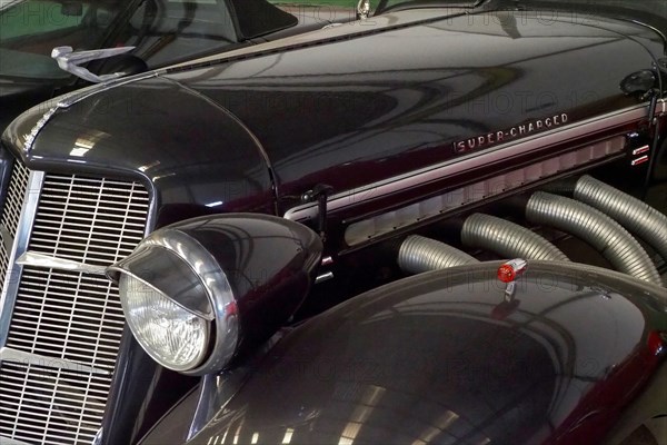 Lamp and radiator grille of a black Auburn Speedster from the side