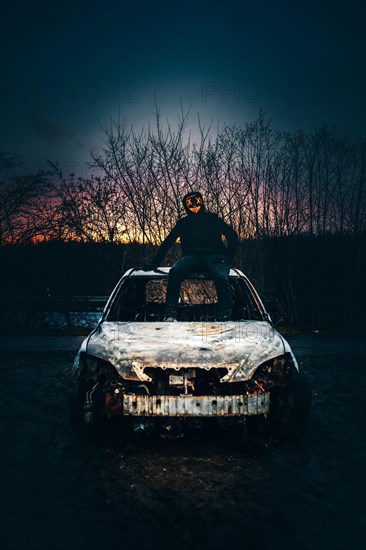 Man with Purge mask on a car wreck