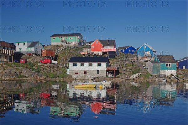 Houses in different colours reflected in the sea