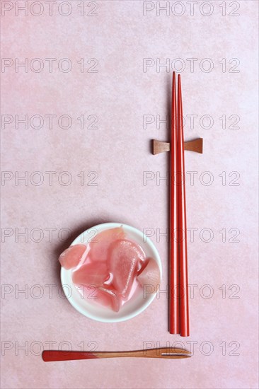 Pickled ginger slices in bowl and chopsticks