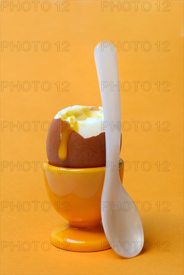 Soft boiled breakfast egg in egg cup with spoon