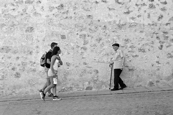 Young couple meets old man with cane