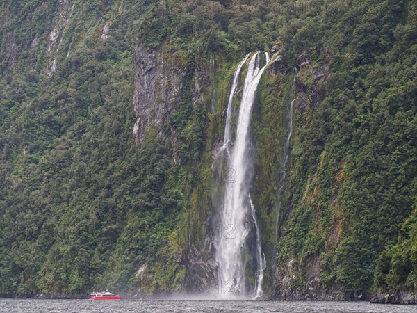 Excursion boat goes to a waterfall in Milford Sound