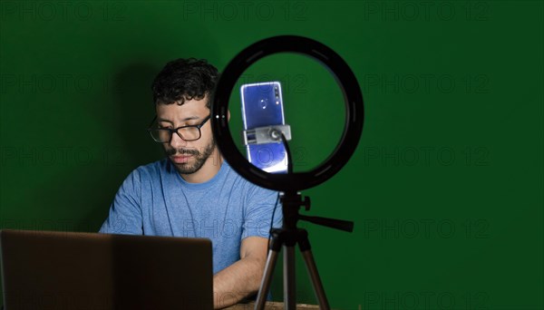 Young man with laptop making video blog