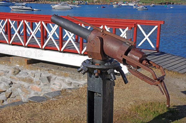 Old whaling harpoon in front of a jetty