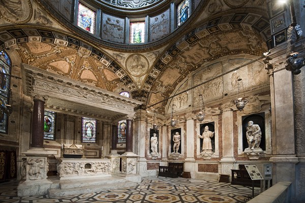 Interior view of richly decorated aisle with marble statues in Genoa Cathedral