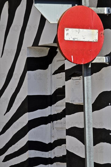 Sign with No trespassing in front of wall with zebra pattern
