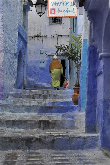 Woman walking up stairs in blue city