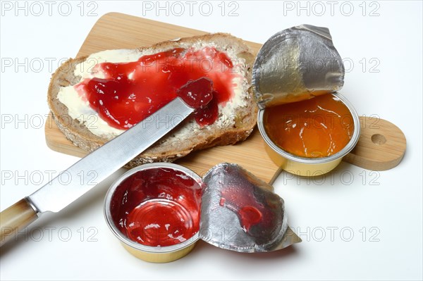 Slice of bread with jam and jam in portion pack