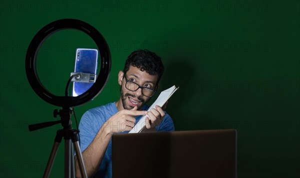 Young man with laptop making video blog