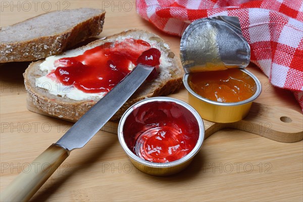 Slice of bread with jam and jam in portion pack