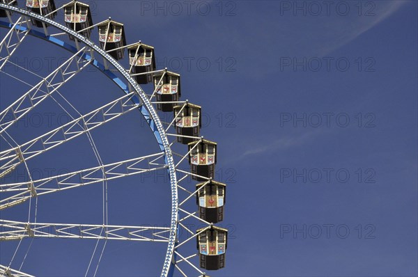 Gondolas from the Ferris wheel against a blue sky