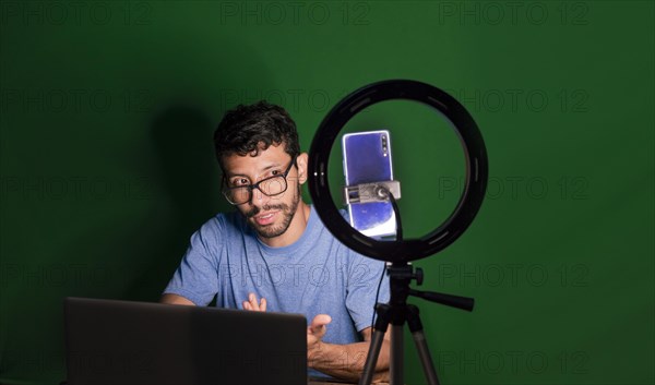 Young man with laptop making video blog