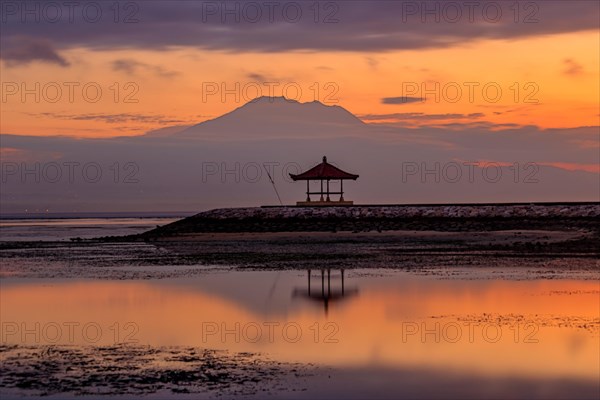Beach with temple in the water and reflection at sunrise
