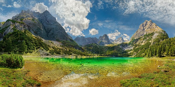 Turquoise Lake Seebensee and the mountain peaks of Tajakopf and Drachenkopf under a bizarre cloudy sky