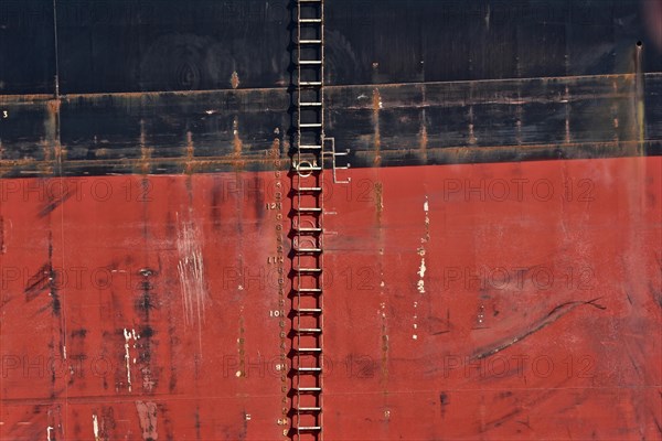 Rope ladder on the red and black side of a freighter