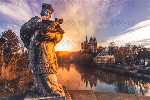 The statue of the bridge saint Nepomuk on the Old Lahn Bridge with the late Romanesque and early Gothic Limburg Cathedral of St. George