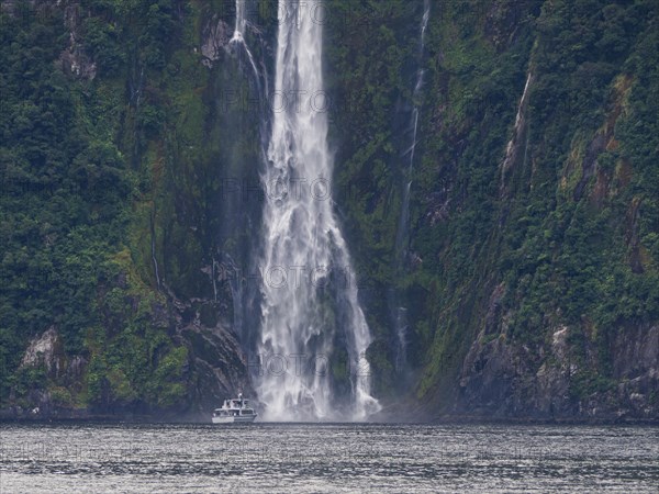 Excursion boat goes to a waterfall in Milford Sound