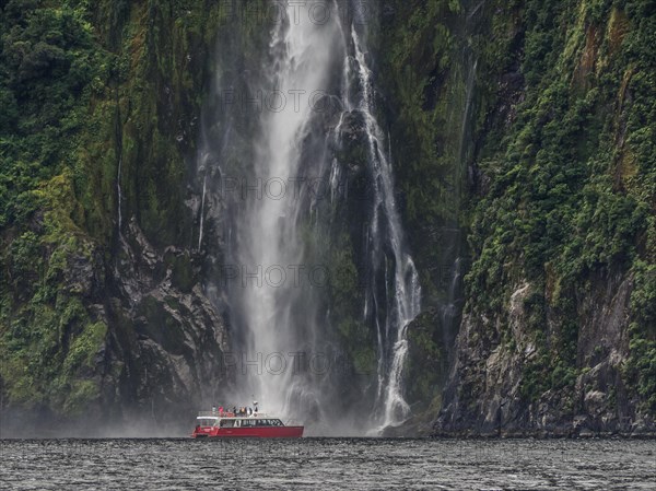 Excursion boat goes to a waterfall in Milford Sound