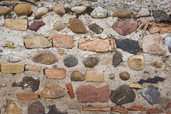 Old wall built with different stones and bricks