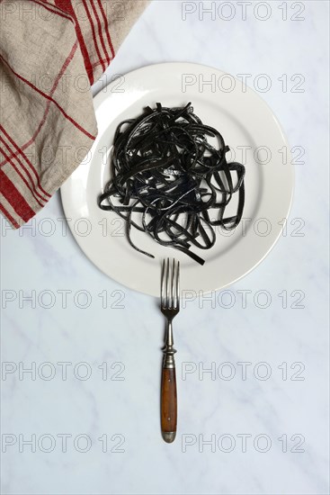 Black pasta with squid ink on plate