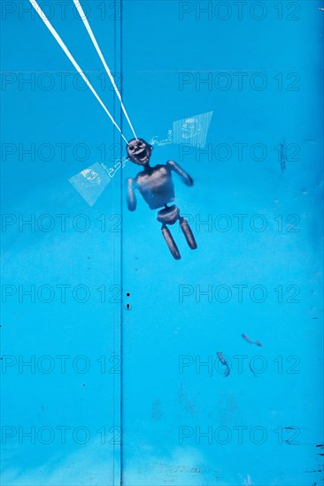 Figure as parachutist at blue metal door