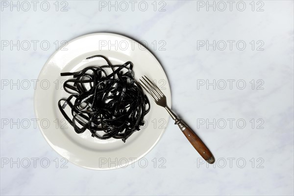 Black pasta with squid ink on plate