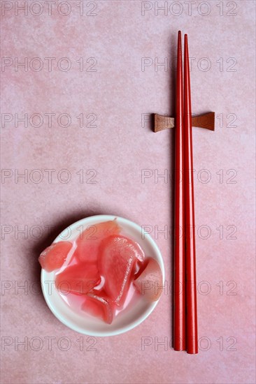 Pickled ginger slices in bowl and chopsticks