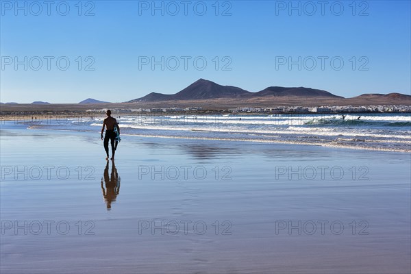 Stroller with surfboard on the beach