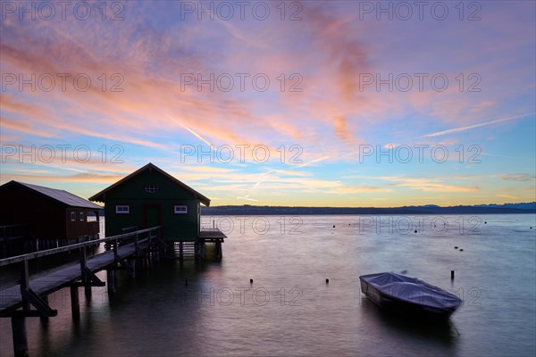 Boathouses with boat at sunrise at the Lake Ammer