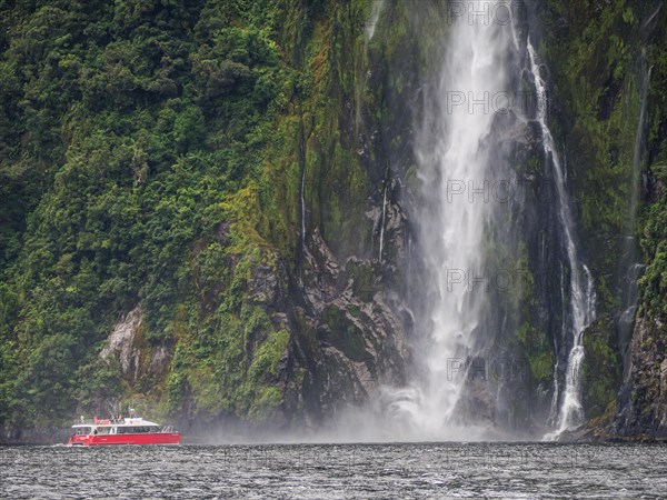 Excursion boat goes to a waterfall in Milford Sound