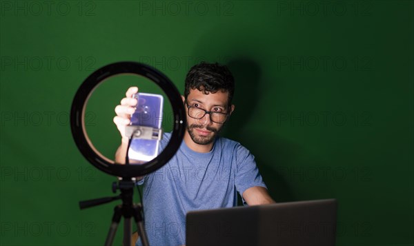 Young man with laptop making video blog