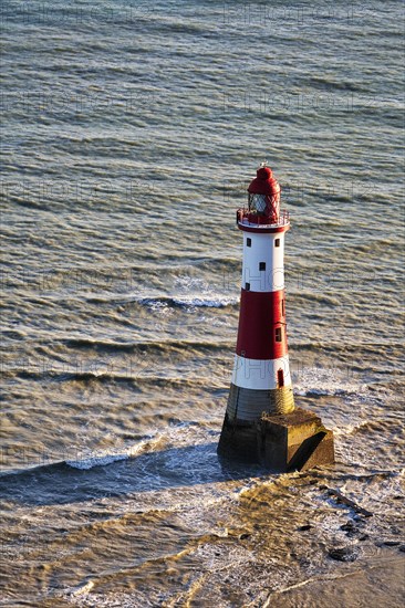 Red and white lighthouse in the sea