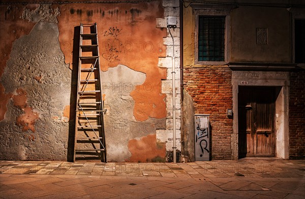 House wall with wooden rung ladder