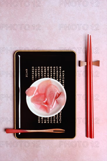 Pickled ginger slices in bowl and chopsticks