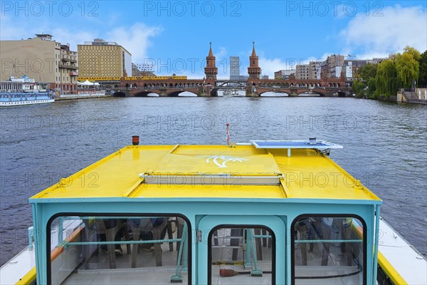 Tourist boat approaching the Oberbaum bridge over the Spree river