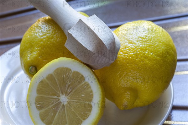 Three yellow lemons on a plate