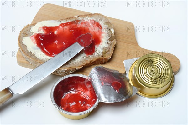 Slice of bread with jam and jam in portion pack