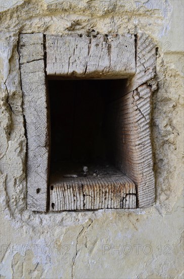 Historic angular door lock made of wood bricked into wall