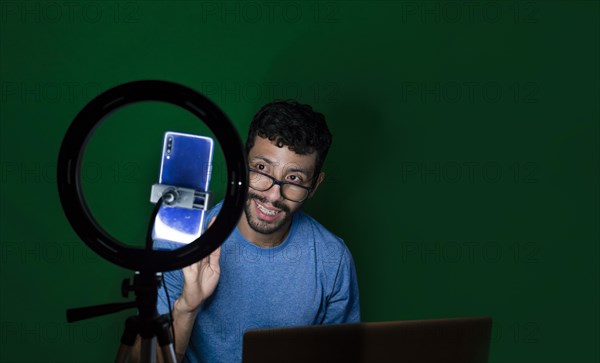 Young man with laptop making video blog