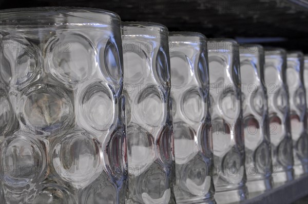 Beer mugs lined up on a shelf